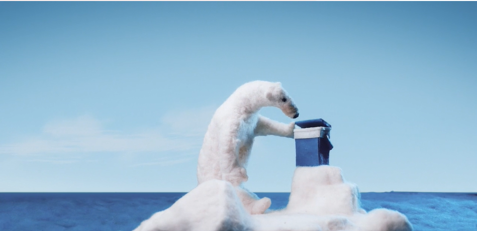 Polar bear standing on iceberg looking into cool box